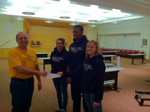 Paul Daigle accepts check presented by HOSA State Officers